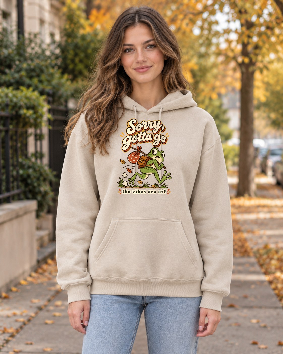 Sorry Gotta Go Frog Hoodie in sand worn by a model