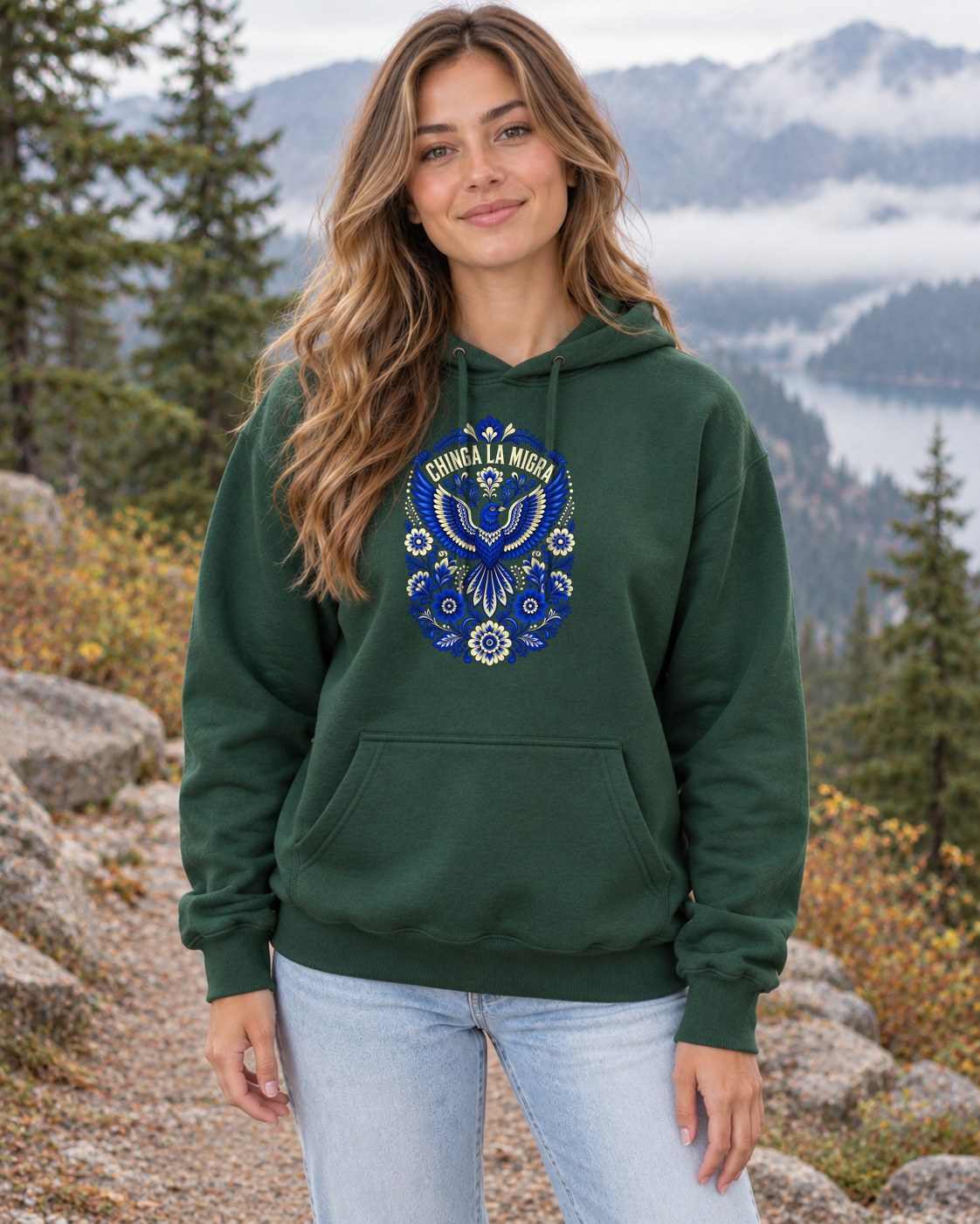 Chinga La Migra Folk Art Hoodie in forest green worn by a model
